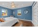 Spacious bedroom with blue walls, wood floors, and ceiling fan at 2885 Hudson St, Denver, CO 80207