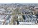An aerial view shows the house surrounded by modern townhomes with the Denver skyline in the background at 1745 Irving St, Denver, CO 80204