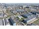 Wide aerial view shows the house surrounded by modern townhomes with the Denver skyline in the background at 1745 Irving St, Denver, CO 80204