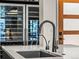The modern kitchen features a sleek faucet, a built-in sink, and dual wine refrigerators at 3133 Blake St # 3, Denver, CO 80205