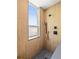 Modern shower stall featuring textured wooden wall tile, sleek fixtures, and natural light from the window at 3133 Blake St # 3, Denver, CO 80205