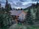 Aerial view of a home featuring a hot tub and spacious back deck, enveloped by pine trees at 96 Carolyn Rd, Evergreen, CO 80439