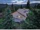 Aerial view of a home with a spacious deck, surrounded by lush green trees and beautiful mountain scenery at 96 Carolyn Rd, Evergreen, CO 80439