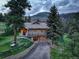 Home exterior with a stone foundation, covered porch, and a beautifully landscaped yard, perfect for outdoor enjoyment at 96 Carolyn Rd, Evergreen, CO 80439