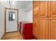 Well-lit laundry room features front-loading machines, wood floors, and natural wood cabinets at 96 Carolyn Rd, Evergreen, CO 80439