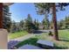 Well-maintained front yard of property has mature trees and a sunny patch of lawn at 96 Carolyn Rd, Evergreen, CO 80439