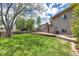 Backyard featuring lawn, trees, and a wooden deck at 1250 Acropolis Dr, Lafayette, CO 80026