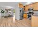 Modern kitchen with stainless steel appliances, wood cabinets, and breakfast bar open to the dining area at 1250 Acropolis Dr, Lafayette, CO 80026