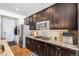 Eat-in kitchen with dark cabinetry, granite counters, and stainless steel appliances at 7097 S Patsburg Way, Aurora, CO 80016