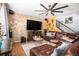 Spacious living room with a stone accent wall, leather furniture, and a large TV at 7097 S Patsburg Way, Aurora, CO 80016