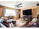 Spacious living room with a stone accent wall, leather furniture, and a large TV at 7097 S Patsburg Way, Aurora, CO 80016