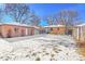 Backyard view of a home with a detached garage and snowy ground at 3126 S Franklin St, Englewood, CO 80113