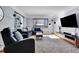 Modern living room with sectional sofa, large TV, and hardwood floors at 3126 S Franklin St, Englewood, CO 80113