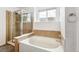 A bright bathroom featuring a soaking tub and glass enclosed shower at 15762 Olmsted Pl, Denver, CO 80239