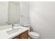 Powder room featuring a wood vanity, white countertop, and modern fixtures at 15762 Olmsted Pl, Denver, CO 80239
