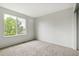 Well-lit bedroom with plush carpeting, neutral walls, and a large window at 15762 Olmsted Pl, Denver, CO 80239