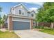 Charming two-story home features blue siding, brick accents, and an attached two-car garage at 15762 Olmsted Pl, Denver, CO 80239
