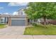 The front of this lovely home has a two-car garage and is partially shaded by a mature tree at 15762 Olmsted Pl, Denver, CO 80239