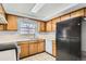 Kitchen with light wood cabinets, black appliances, and tiled floor at 13440 W 7Th Ave, Lakewood, CO 80401