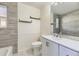 Bathroom with white vanity, modern sink, wood shelves, wainscoting, and gray wood-look tile at 4689 Tanner Peak Trl, Brighton, CO 80601