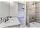 Well-lit bathroom with a combined tub and shower, modern fixtures, and gray wood-look tile at 4689 Tanner Peak Trl, Brighton, CO 80601
