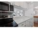 Modern kitchen with white cabinets and stainless steel appliances at 2 Adams St # 1401, Denver, CO 80206