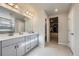 Sleek bathroom featuring double sinks, modern fixtures, and a walk-in closet at 9099 Sedalia St, Commerce City, CO 80022