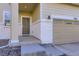 Inviting front porch with a gray door and white brick accents, next to a gray two-car garage at 9099 Sedalia St, Commerce City, CO 80022