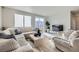 Bright living room with a large sofa, plush armchairs, and a sliding glass door to the exterior at 9099 Sedalia St, Commerce City, CO 80022