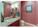 Stylish half bathroom with a vanity, decorative mirror, and elegant lighting fixtures at 7132 S Irvington Ct, Aurora, CO 80016