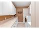 Bright laundry room with white cabinets, sink, and modern washer and dryer at 7132 S Irvington Ct, Aurora, CO 80016