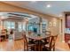 Cozy living room featuring a stone fireplace, wood beams, and a view into the kitchen and dining area at 7132 S Irvington Ct, Aurora, CO 80016