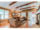 Bright living room with vaulted ceilings, wood beams, and access to an outdoor patio at 7132 S Irvington Ct, Aurora, CO 80016
