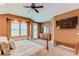 Bright main bedroom with a ceiling fan, a sitting area, and a dresser with a mirror at 7132 S Irvington Ct, Aurora, CO 80016