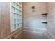 Shower featuring neutral tile, a glass block window, and built in shelves at 7132 S Irvington Ct, Aurora, CO 80016