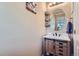 Cozy half bathroom with a mirror, sink, modern vanity, wood floors, and neutral wall color at 24748 E Layton Pl, Aurora, CO 80016