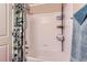 Clean, white tiled bathtub and shower combination with shower caddy for storage at 24748 E Layton Pl, Aurora, CO 80016