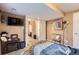 A bright bedroom with a playful aesthetic includes a TV, electric fireplace and comfortable chair at 24748 E Layton Pl, Aurora, CO 80016