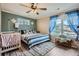 Bright bedroom featuring wood-look floors, a ceiling fan, and a cozy crib for a Bedroom at 24748 E Layton Pl, Aurora, CO 80016