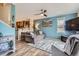 Comfortable living room featuring wood floors, modern ceiling fan and blue accent wall open to kitchen at 24748 E Layton Pl, Aurora, CO 80016