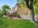 Spacious backyard with well-manicured lawn, white fence, and pergola covered patio at 6293 Braun Cir, Arvada, CO 80004