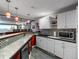 Finished basement wet bar features bar seating, cabinets, and a drink refrigerator at 6293 Braun Cir, Arvada, CO 80004