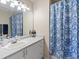 Bathroom with single sink vanity, decorative mirror, and blue floral shower curtain at 6293 Braun Cir, Arvada, CO 80004