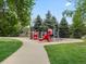 Neighborhood playground area with a colorful playset, climbing structures, and safety surfacing surrounded by green grass at 6293 Braun Cir, Arvada, CO 80004