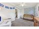 Bright Bedroom with stylish wallpaper, comfortable seating, and a wooden crib for a cozy space at 721 Park Ln, Lakewood, CO 80214