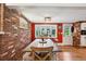 Warm dining room with hardwood floors and a brick accent wall with a stained glass window at 721 Park Ln, Lakewood, CO 80214