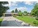 Inviting home featuring a green lawn, mature trees, a two-car garage, and lovely neighborhood views at 721 Park Ln, Lakewood, CO 80214