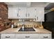 White kitchen cabinets and tile countertop with modern stainless steel appliances at 721 Park Ln, Lakewood, CO 80214