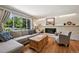 Bright living room featuring hardwood floors, large window, neutral furnishings, and a cozy brick fireplace at 721 Park Ln, Lakewood, CO 80214