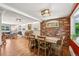 Open-concept living space featuring a brick accent wall, fireplace, and dining area at 721 Park Ln, Lakewood, CO 80214